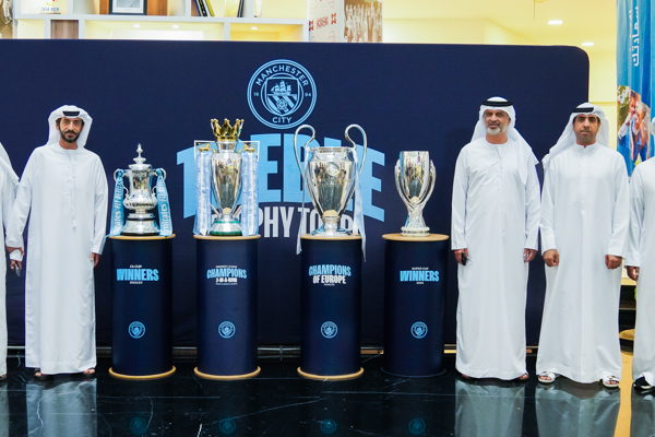 موظفو "أبوظبي الرياضي" يحتفون بكؤوس مانشستر سيتي بمقرهم في أبوظبي 
